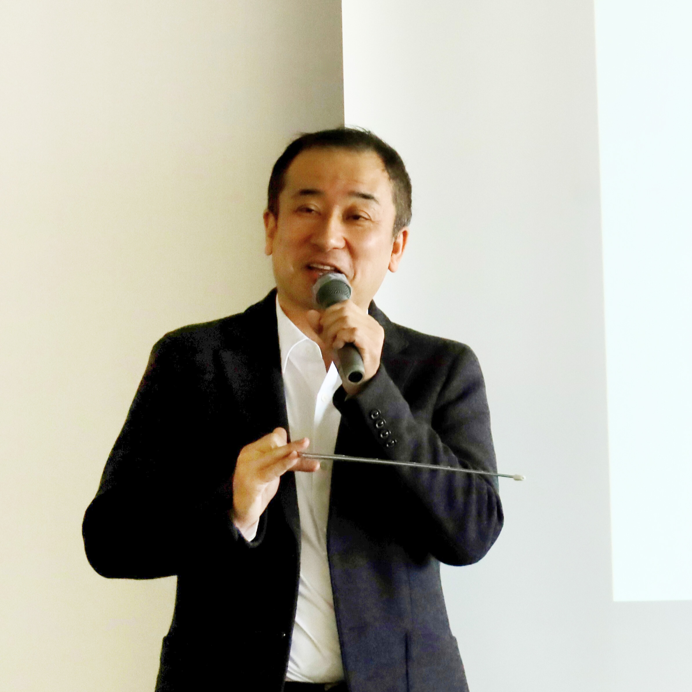 講演会でマイクをもちながら話しをしているこにしかずよしさん